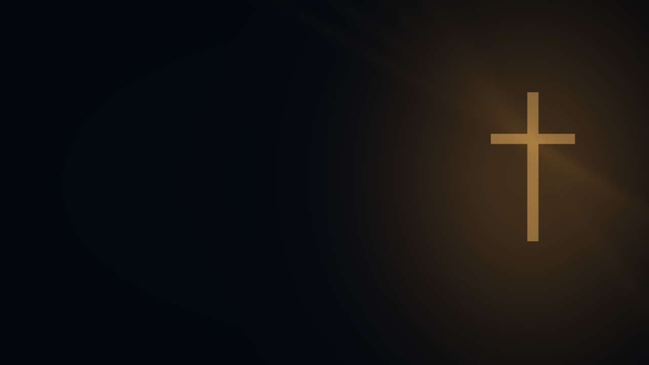 A quiet cross rests in a warm pool of light.